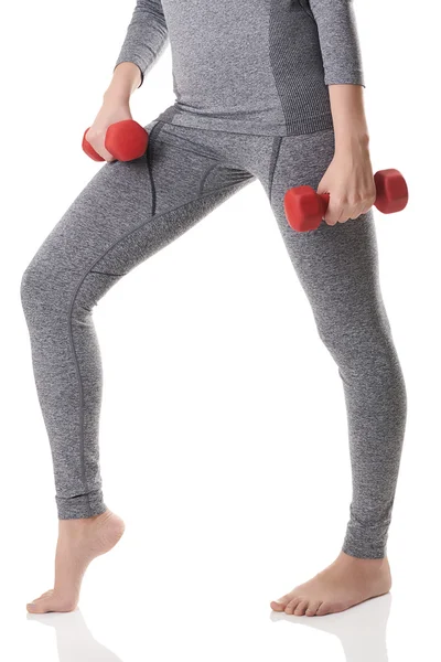 En kvinna passar ben, kropp, händer i grå sport Värmeunderkläder gör övningar med röda hantlar. — Stockfoto
