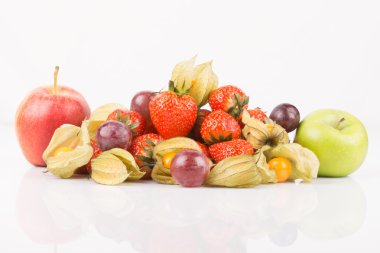 Kırmızı ve yeşil elma portakal physalis, mor üzüm ve beyaz zemin üzerine kırmızı çilek ile.