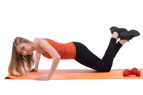 Mooie vrouw in sportkleding opleiding handen, schouders en rug op een mat — Stockfoto