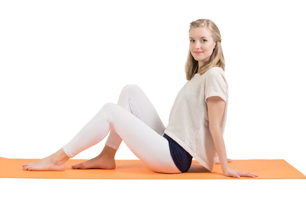 Aantrekkelijke blonde vrouw opleiding buik, billen, heupen en benen op een mat — Stockfoto