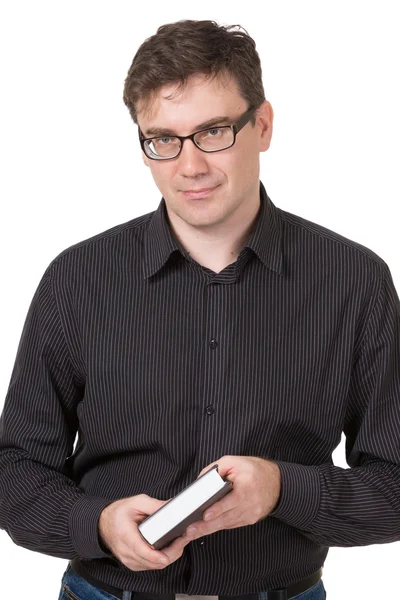 En mand iført jeans og skjorte holder på hænder en interessant bog - Stock-foto