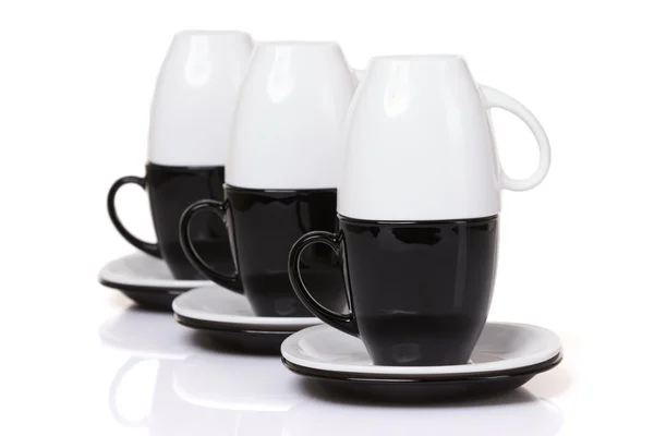 Omvendte hvide kopper står på sorte kopper med stack plader . - Stock-foto