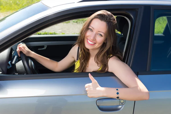 Femme heureuse montrant un bon signe dans la voiture . — Photo