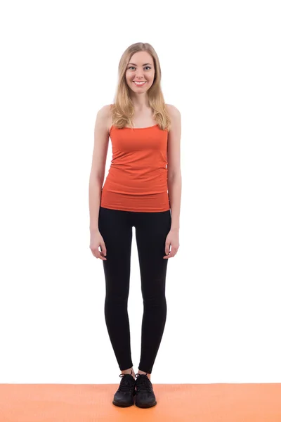 Lächelnde Frau in Sportbekleidung, die Beine und Hände auf einer Matte trainiert. — Stockfoto