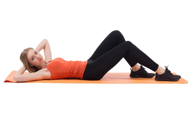 Mujer hermosa entrenamiento prensa acostado en una estera . — Foto de Stock