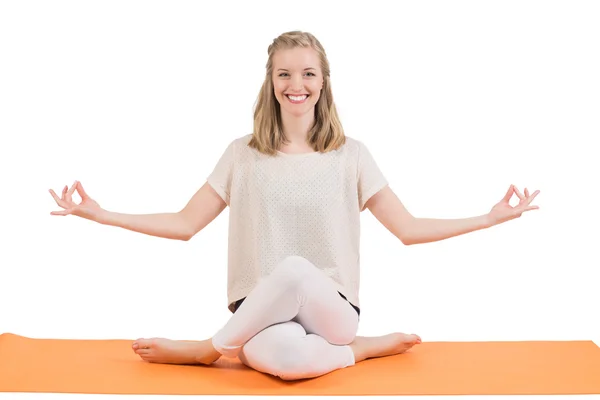 Gelukkig mooie blonde vrouw doet yoga op een mat. — Stockfoto