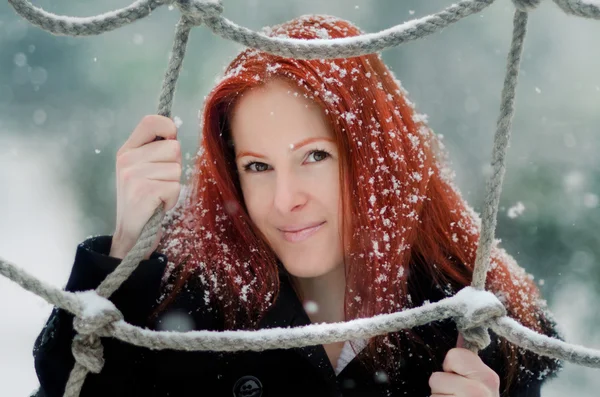 Красивая рыжая девушка в снегу — стоковое фото