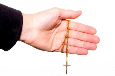 Bir zincir altın haç, üzerinde beyaz izole el tutar