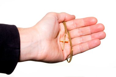 El altın haç olan bir zincir tutar