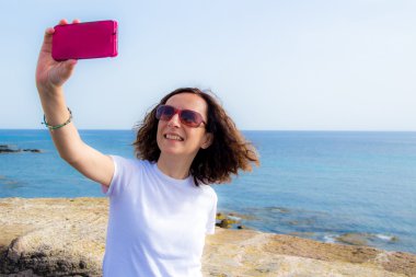 genç kadın selfie önünde denizin bir akıllı telefon ile alır