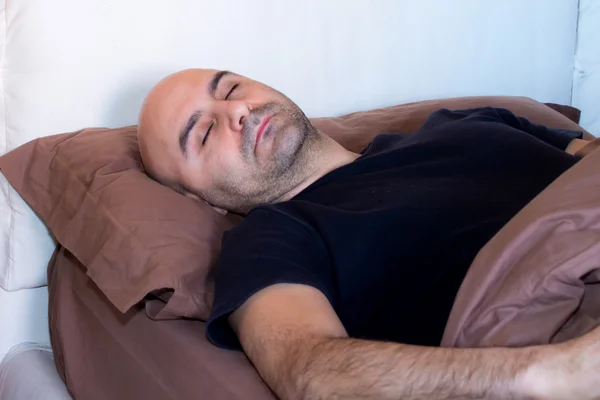 Mężczyzna śpiący na łóżku — Zdjęcie stockowe