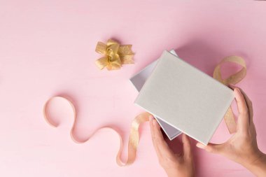 Pembe arka planda altın kurdeleli gümüş hediye kutusu, özel bir gün için hediye, Top View