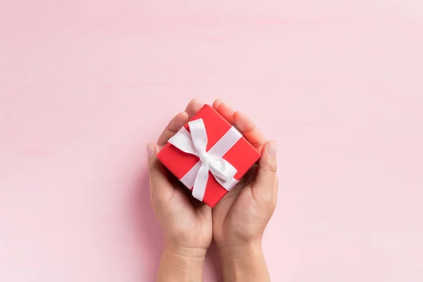 Caja Regalo Roja Con Cinta Blanca Sosteniendo Mano Sobre Fondo — Foto de Stock