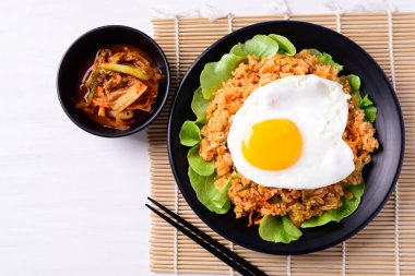 Kızarmış kimchi pilavı, üstünde yumurta ve taze kimçi lahanası, Kore yemeği, Top view.