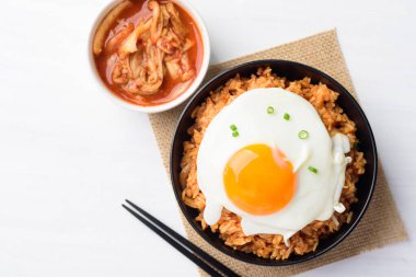 Kore yemeği, kimchi pilavı ve kızarmış yumurta kabında taze kimçiyle yenir.