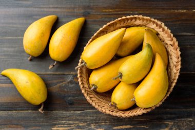 Tahta masadaki bir sepetteki yumurta ya da teneke kutu, Tayland meyvesi Xiantao, Lamut Khamen ya da Mon khai gibi Tayland adlarında.