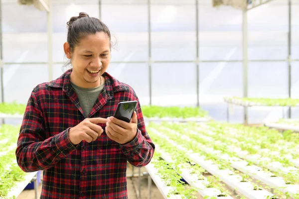 아시아의 농부가 농장에서 관리하기 스마트폰을 사용하는 — 스톡 사진