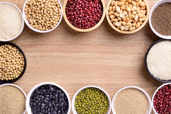 Various cereal grain in a bowl on wooden background (quinoa seeds, black kidney bean, peanut, perilla seeds, soybean, azuki beans, rice grain and mung beans)