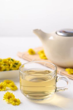 Organik Kasımpatı çiçeği çayı bir fincanda ve çaydanlık beyaz arka planda, sağlıklı bitkisel içecek