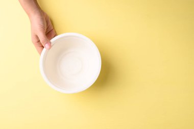 Sarı arka planda (biyolojik olarak ayrıştırılabilir, gübrelenebilir, tek kullanımlık veya çevre dostu kase), sürdürülebilir konsept