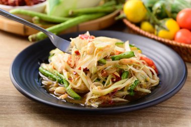 Tayland yemeği (Som tum), baharatlı yeşil papaya salatası ve çatalla yenen sebzeler