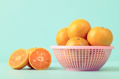 Renkli bir sepette taze mandalina portakal meyvesi.