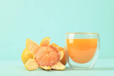 Taze mandalina portakal suyu ve arka planda cam suyu.