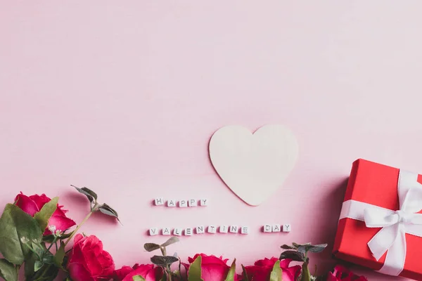 美しい赤いバラの花の花束ギフトボックスと幸せなバレンタインデーピンクの背景にハート型のアルファベット — ストック写真