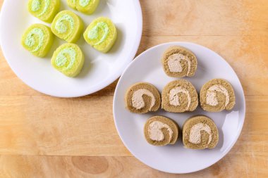 Kahveli kek ve ahşap arka planda kremalı pasta.