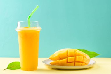 Bardakta taze mango püresi ve rengarenk mango meyvesi dilimlenmiş tropikal içecek.