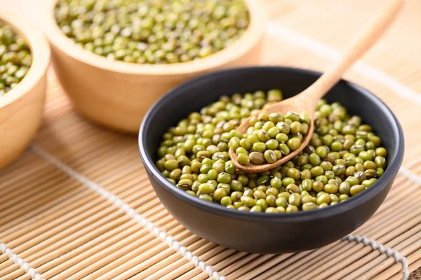 Mung bean seeds in a wooden spoon and bowl, Food ingredients in Asian cuisine and produce mung bean sprout