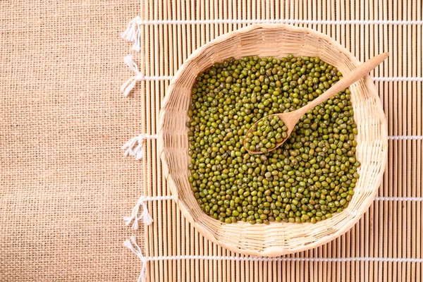 Mung bean seeds in wooden spoon and bamboo basket, Food ingredients in Asian cuisine and produce mung bean sprout