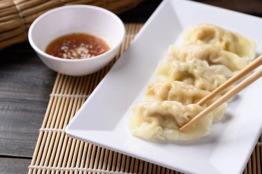 İnce dilimlenmiş domuz eti ve karidesle doldurulmuş buğulanmış wonton köftesi. Yemek çubukları ve Asya mutfağı ile susam yağı sosuyla yenir.