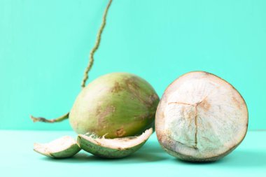 Yeşil arka planda soyulmuş taze hindistan cevizi meyvesi, yaz tropikal meyvesi