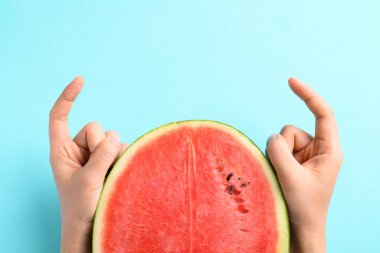 Yarı karpuz meyvesi, arka planda iki parmak, Tropikal meyve, yaz mevsimi