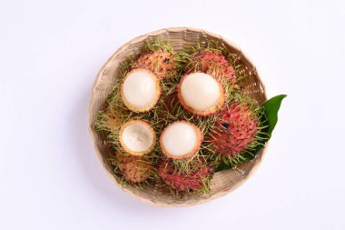 Beyaz arka planda bambu sepetinde olgun Rambutan meyvesi, tropikal meyve ve yerli Güneydoğu Asya, sulu ve tatlı bir tadı var.