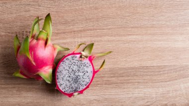 Tahta arka planda ejderha meyvesi veya pitaya, tropikal meyve, masa üstü görünümü