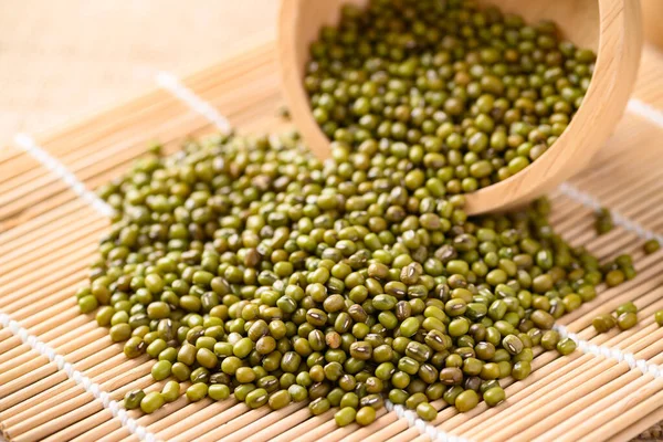 Pile of mung bean seeds in a wooden bowl, Food ingredients in Asian cuisine and produce mung bean sprout