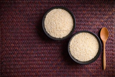 Kaşıklı bir kasede beyaz susam tohumu.