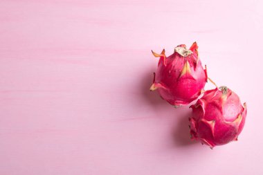 Olgun ejderha meyvesi ya da pitaya pembe arka planda fotokopi alanı, tropikal meyve