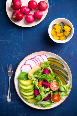 Avokado, ejderha meyvesi, turp, balkabağı, domates, mısır salatası, marul, mizuna ve limonlu sebze yemeği. Sağlıklı yemek.
