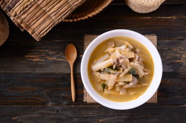 Yerel Tayland yemekleri, baharatlı muz sapı çorbası ahşap arka planda bir kasede domuz eti, masa üstü manzarası.