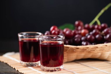 Bardakta kırmızı üzüm suyu, sepette taze üzüm, sağlıklı içecek, natürmort.