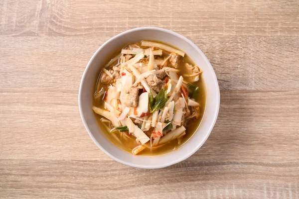 stock image Local Thai food, Fermented bamboo shoot spicy soup with pork in a bowl on wooden background, Table top view