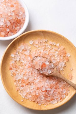 Top view of Himalayan pink salt in wooden plate with spoon, Healthy food ingredient