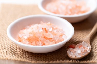 Himalayan pink salt in bowl with spoon, Healthy food ingredient