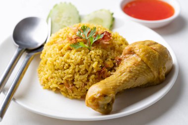 Beyaz arka planda tavuk ve acı soslu Tayland biryani pilavı.