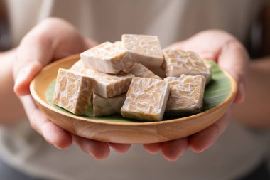 Elle tutulan tahtadan yapılmış mayalanmış soya fasulyesinden yapılan Tempeh geleneksel Endonezya yemekleri, sağlıklı vegan ve bitki bazlı malzemeler