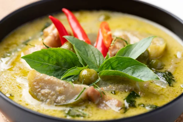 Thai green curry chicken in black bowl, Close up