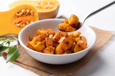 Roasted butternut squash pumpkin in a bowl with spoon, Autumn homemade food